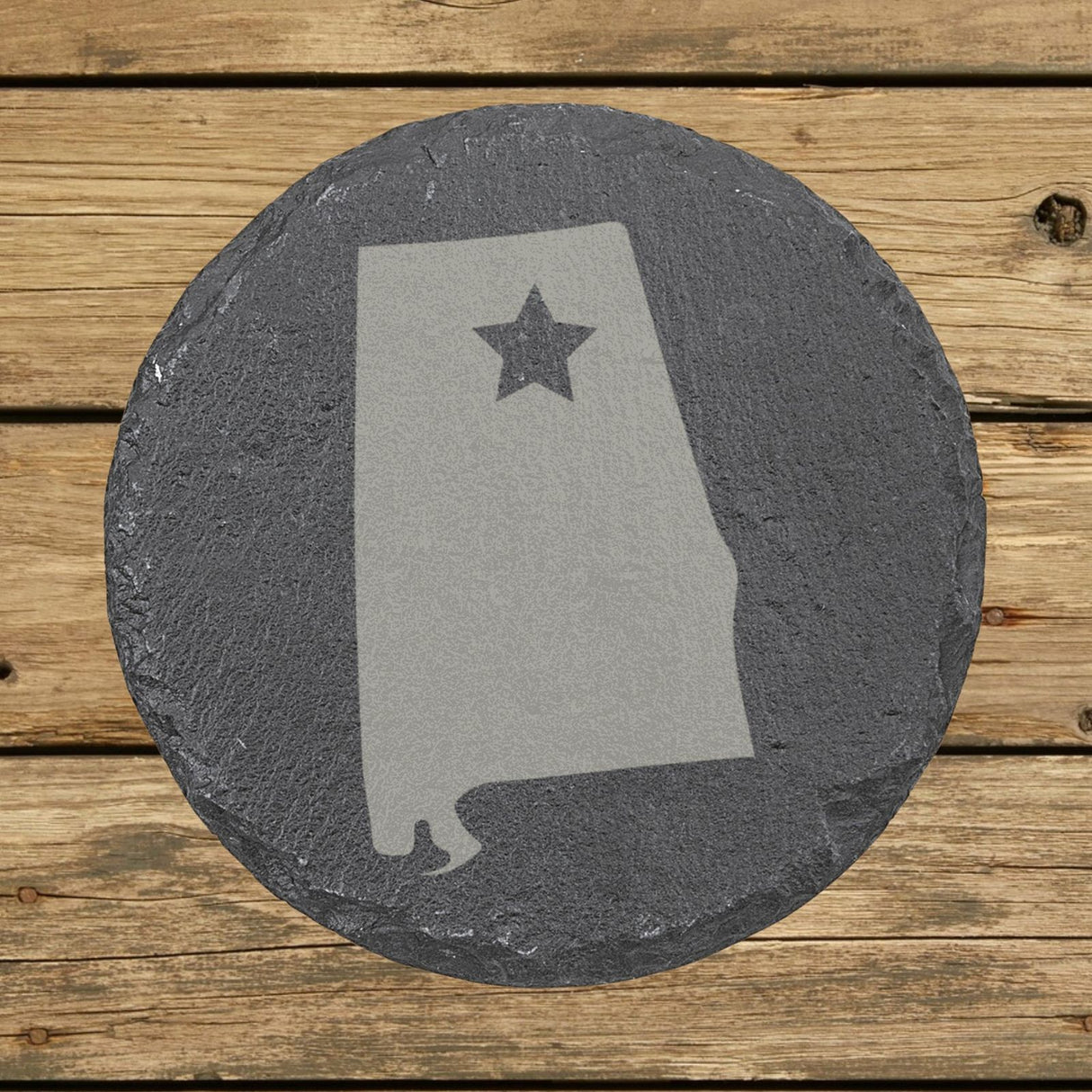 Alabama round slate coaster engraved with the state shape and a star