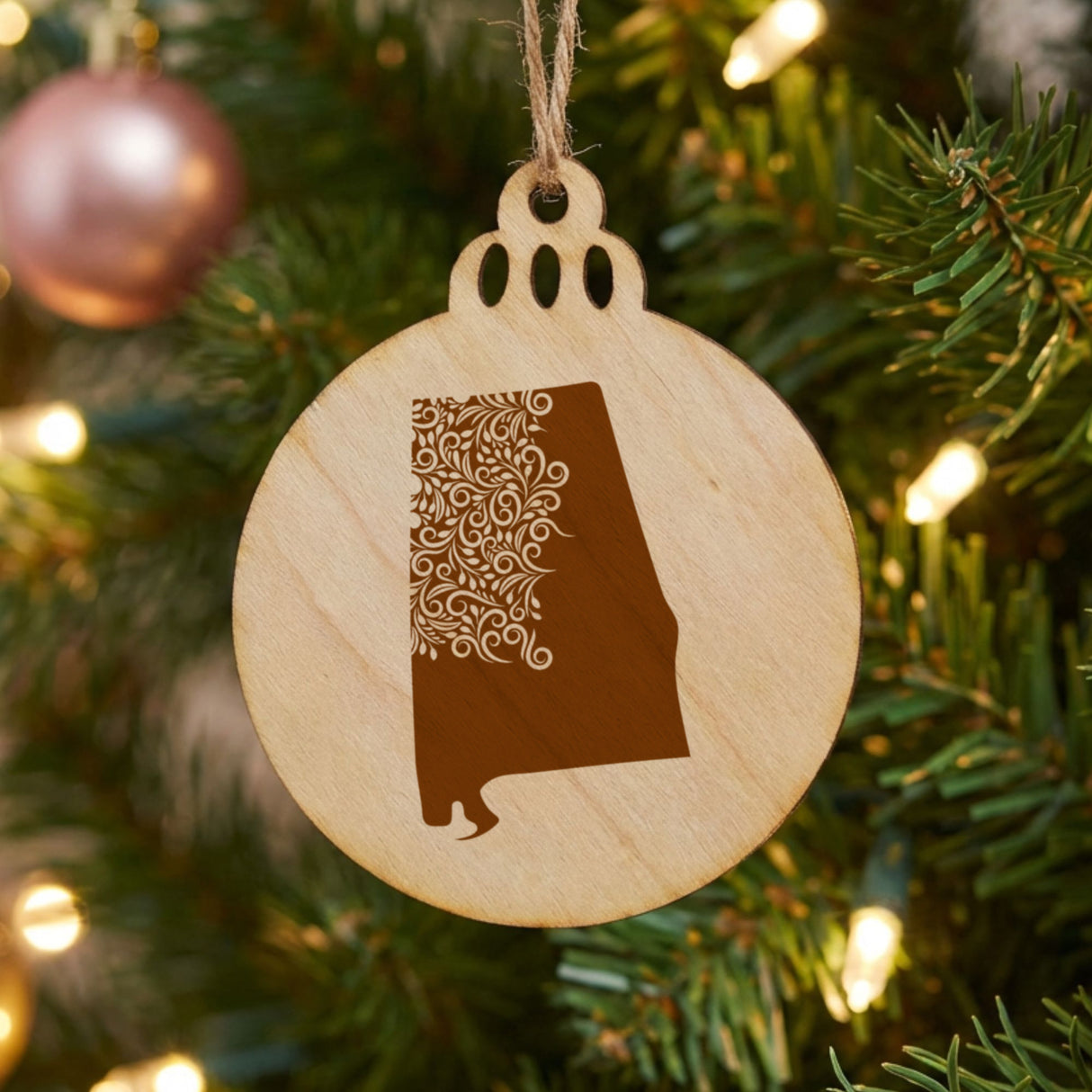 Alabama round wood Christmas ornament engraved with the state shape in ornate floral scrollwork