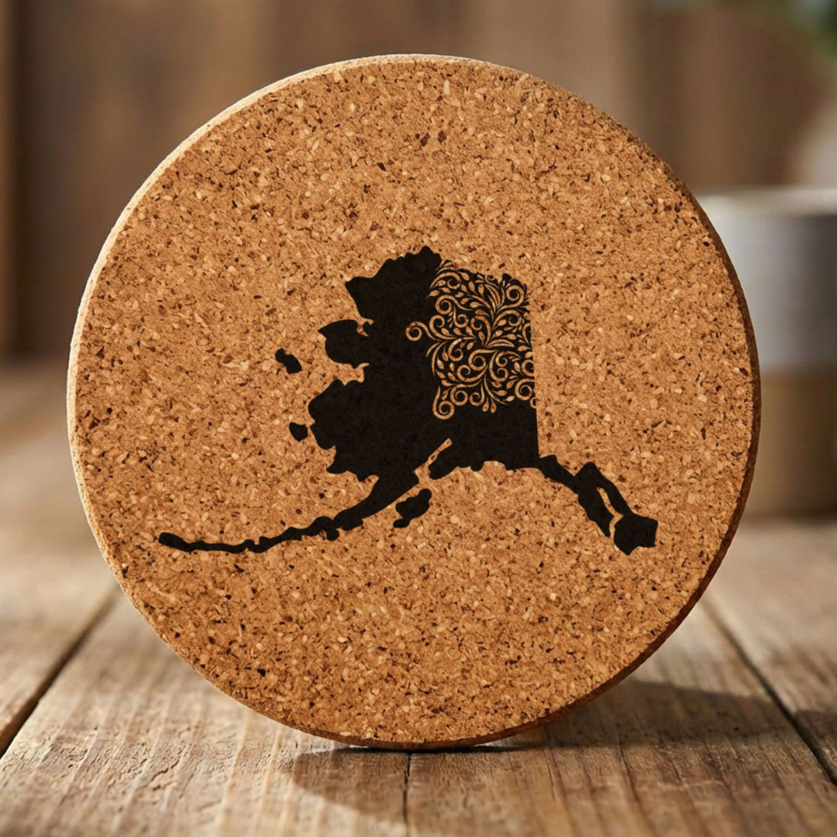 Alaska round cork coaster engraved with the state shape in ornate floral scrollwork