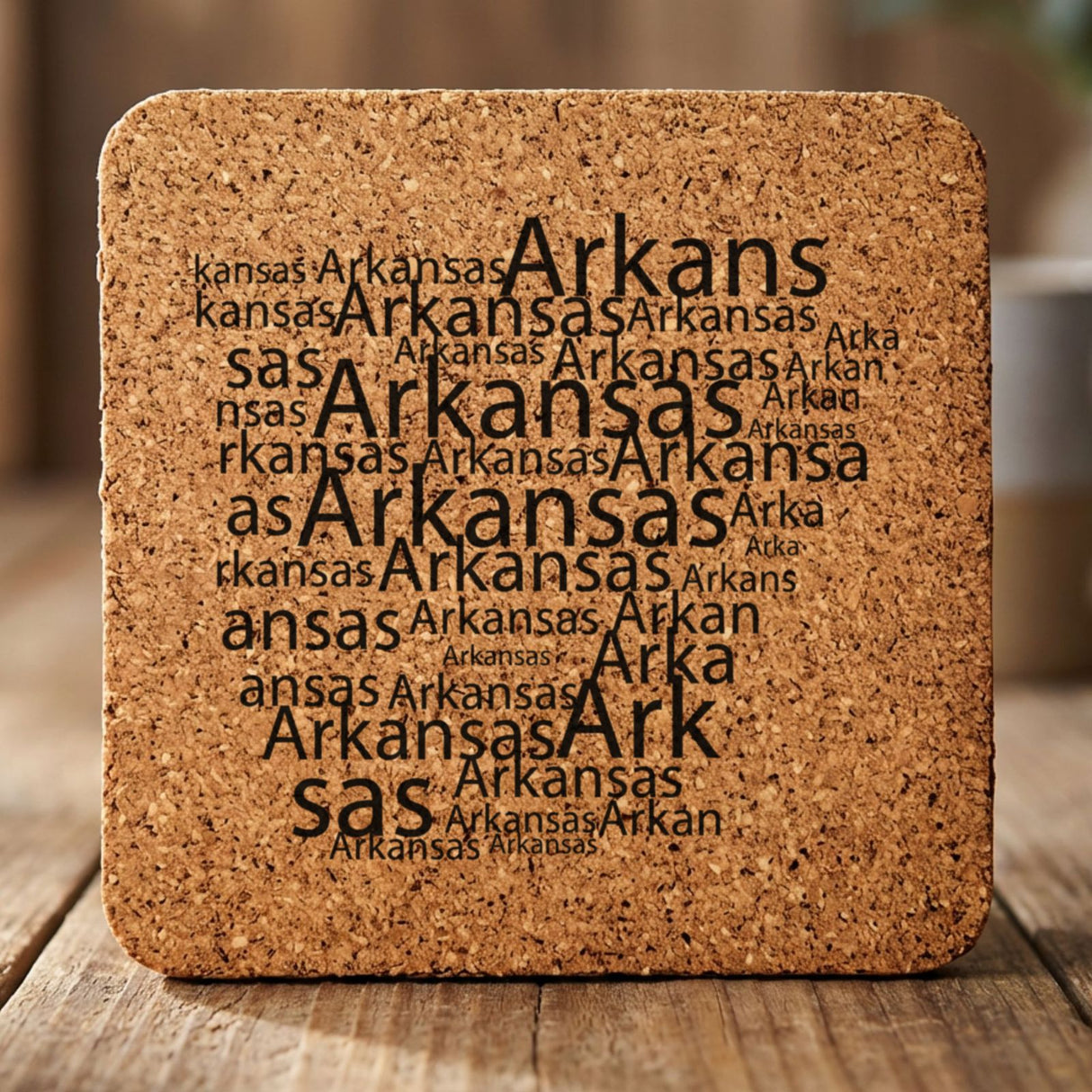 Arkansas square cork coaster engraved with a word cloud of repeating Arkansas text