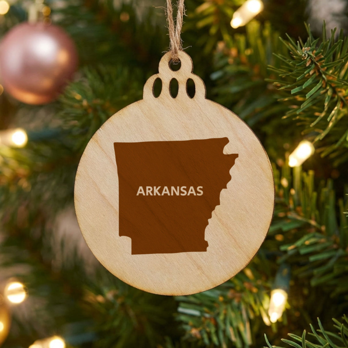 Arkansas round wood Christmas ornament engraved with the state shape and ARKANSAS in bold lettering