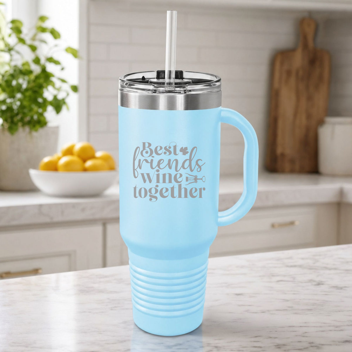 Light Blue 40 oz tumbler with handle and straw laser engraved with "Best Friends Wine Together", on a kitchen counter