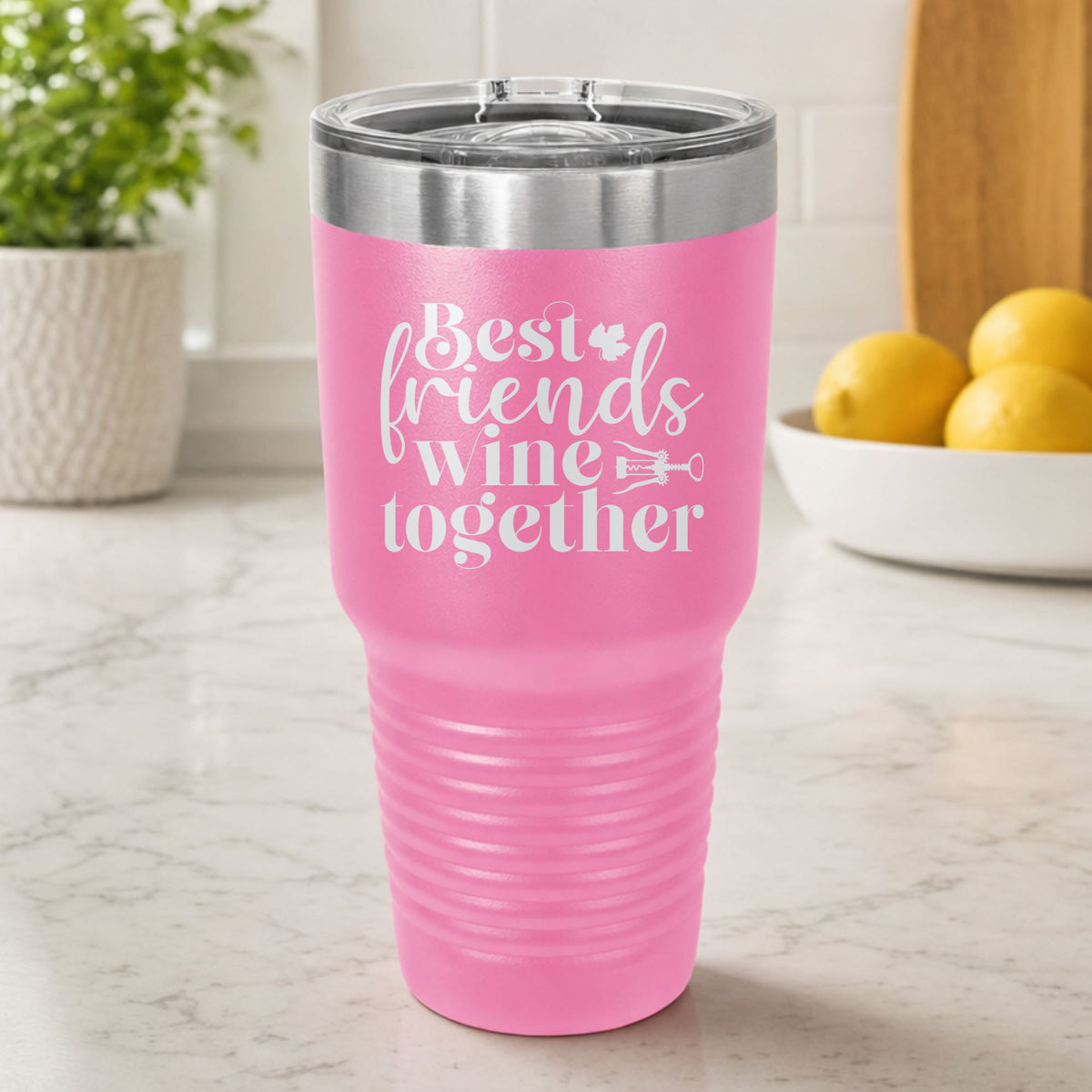 Pink 30 oz tumbler laser engraved with "Best Friends Wine Together", on a kitchen counter