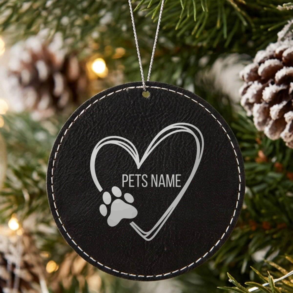 Black leatherette Christmas ornament engraved with the heart and paw print design