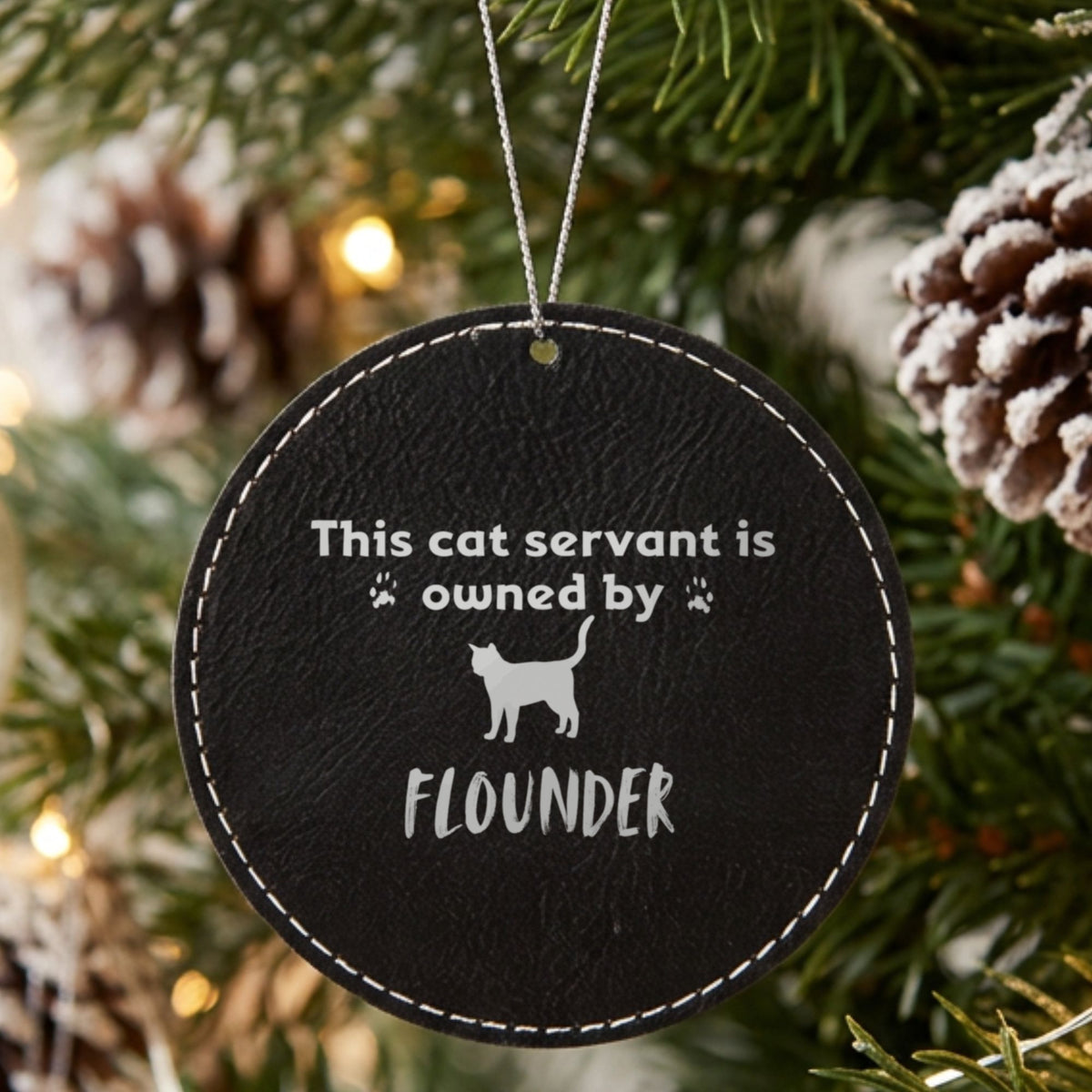 Black leatherette Christmas ornament engraved with the This Cat Servant is Owned By design and a sample pet name