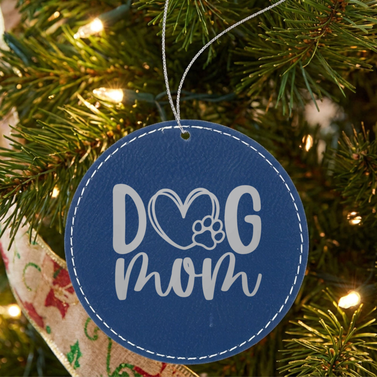 Blue leatherette Christmas ornament engraved with a hand drawn Dog Mom heart and paw design