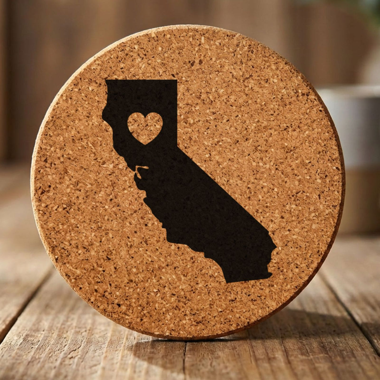 California round cork coaster engraved with the state shape and a heart