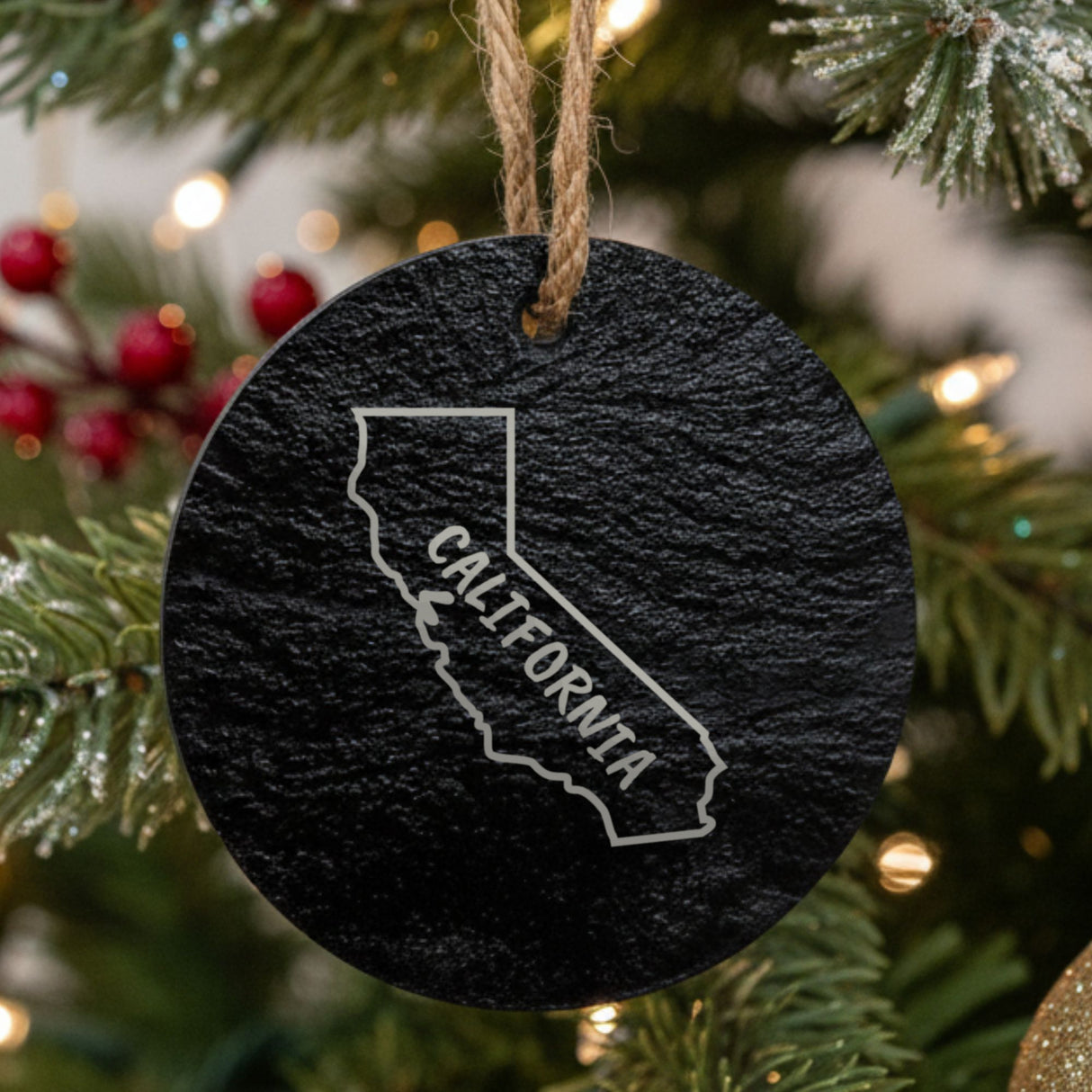 California round slate Christmas ornament engraved with the state outline and CALIFORNIA in hand-drawn brush lettering