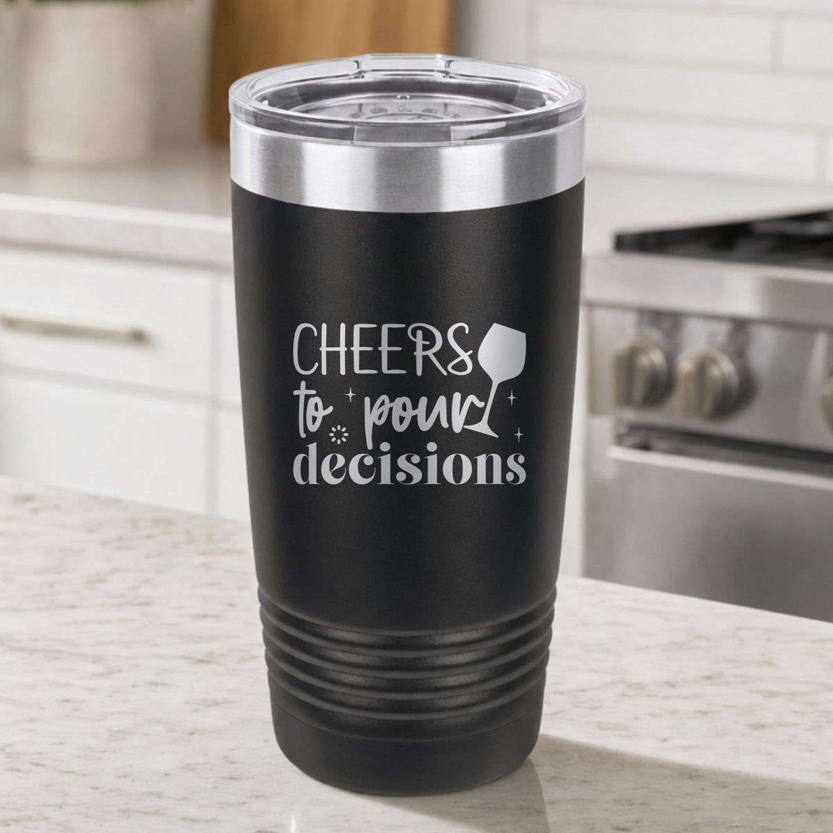 Black 20 oz tumbler laser engraved with "Cheers to Pour Decisions", on a kitchen counter