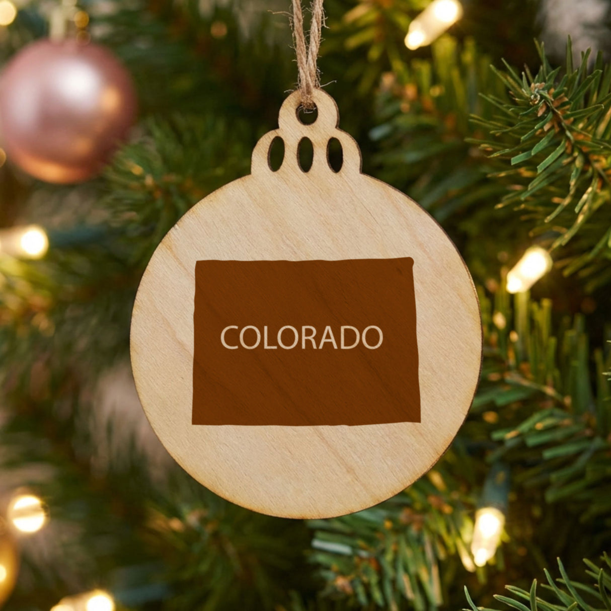 Colorado round wood Christmas ornament engraved with the state shape and COLORADO in bold lettering