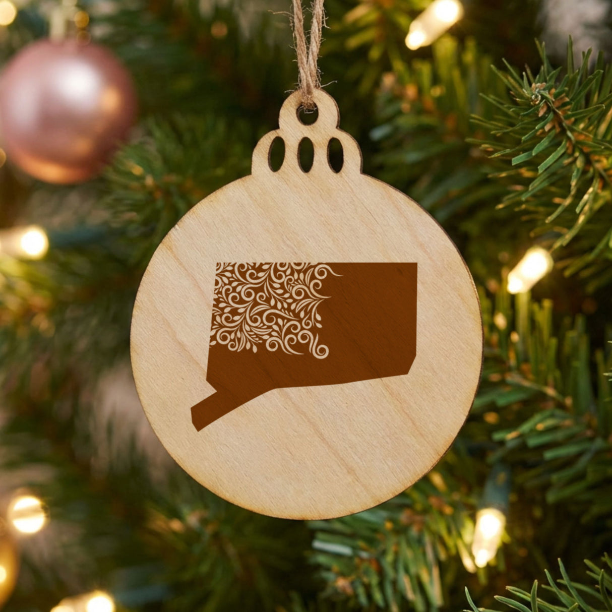 Connecticut round wood Christmas ornament engraved with the state shape in ornate floral scrollwork