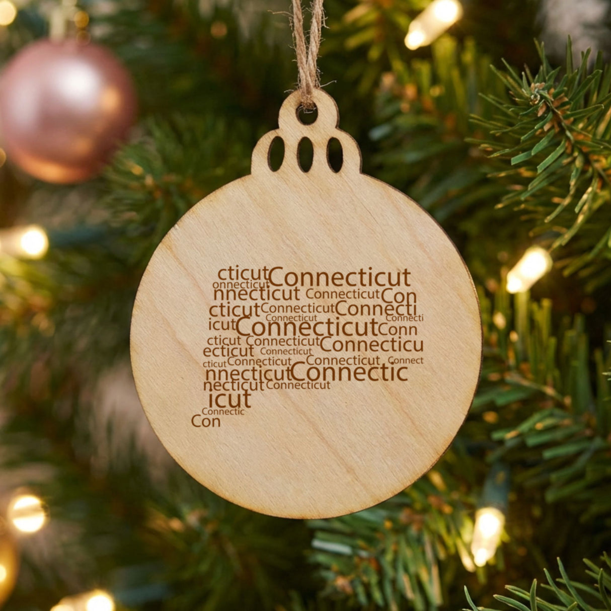 Connecticut round wood Christmas ornament engraved with a word cloud of repeating Connecticut text