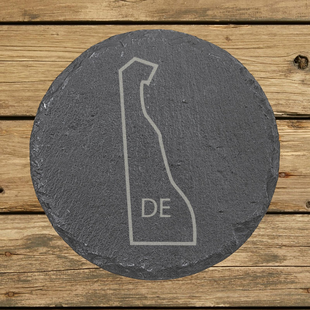 Delaware round slate coaster engraved with the state outline and DE initials