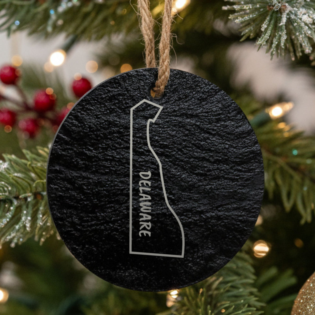 Delaware round slate Christmas ornament engraved with the state outline and DELAWARE in vertical lettering
