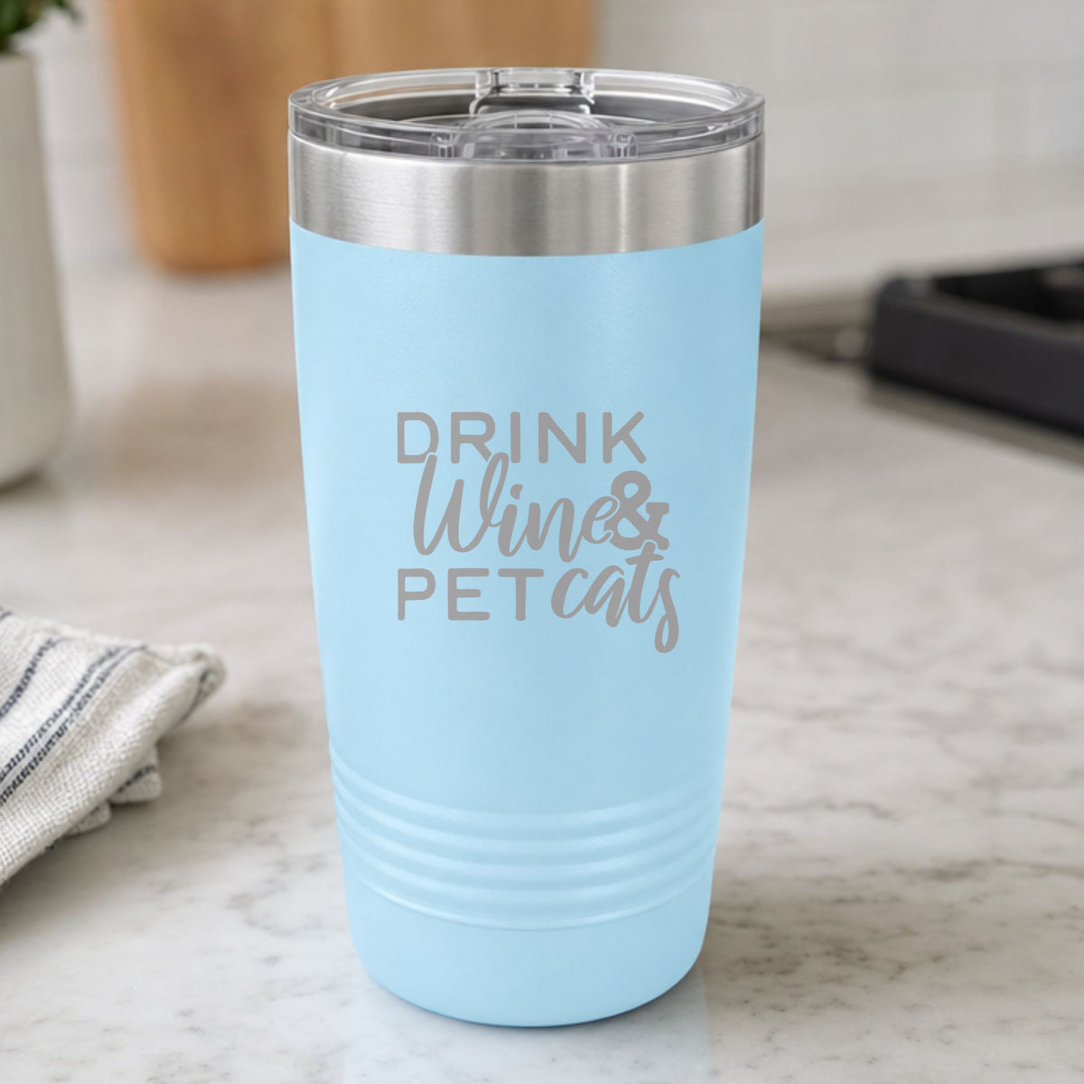 Light Blue 20 oz tumbler laser engraved with "Drink Wine & Pet Cats", on a kitchen counter