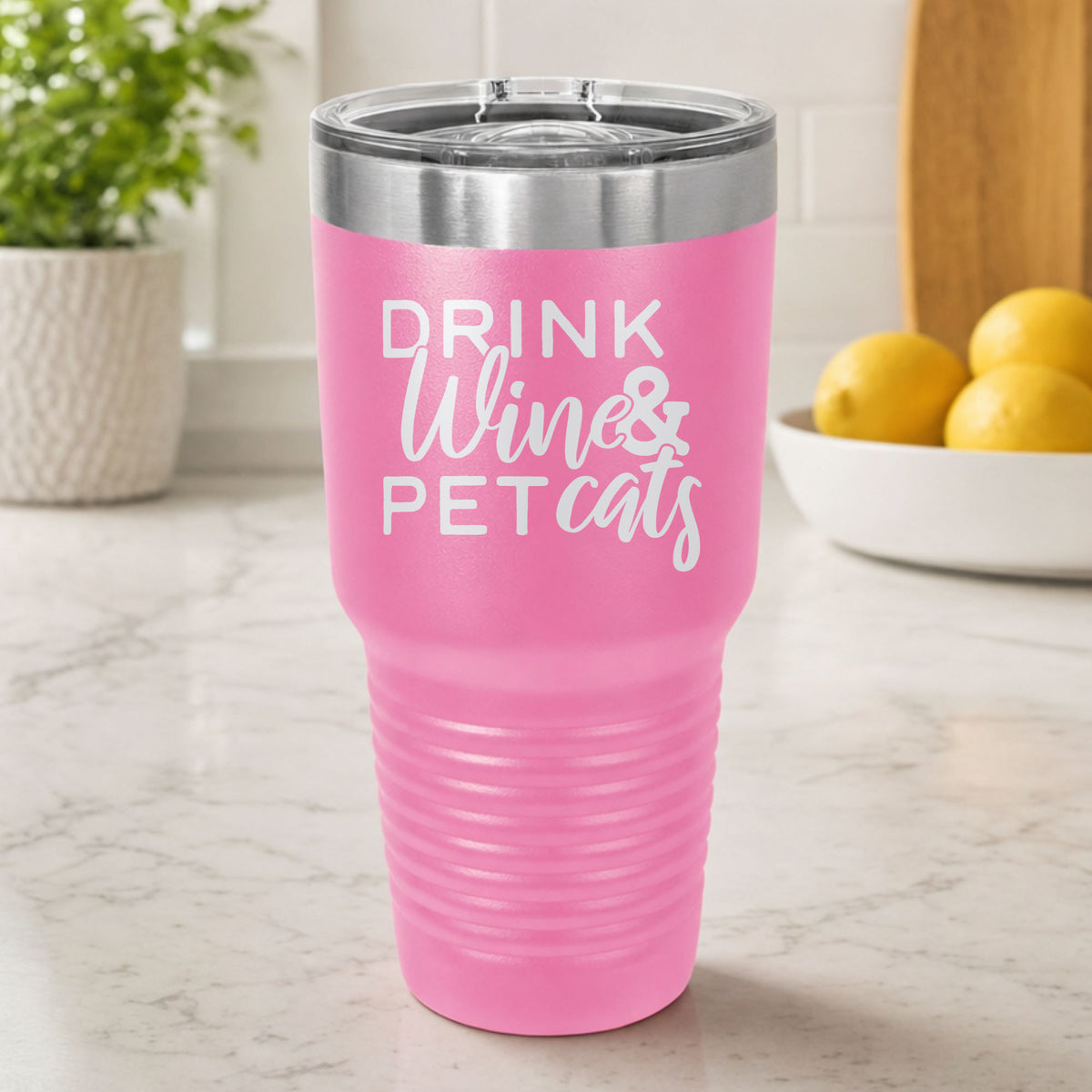 Pink 30 oz tumbler laser engraved with "Drink Wine & Pet Cats", on a kitchen counter