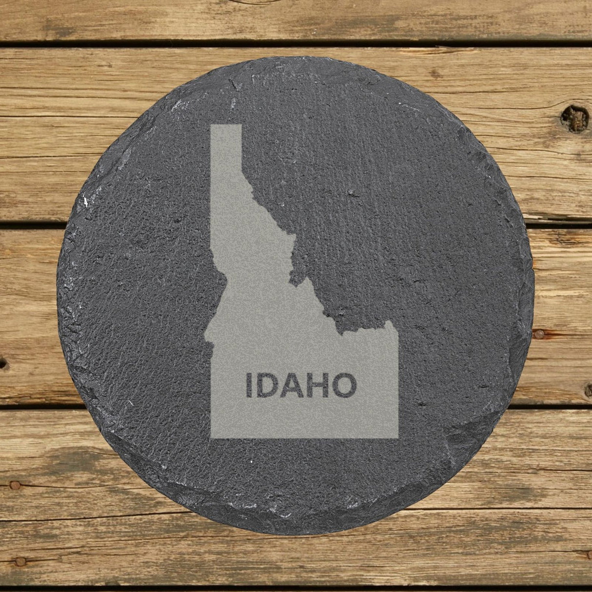 Idaho round slate coaster engraved with the state shape and IDAHO in bold lettering