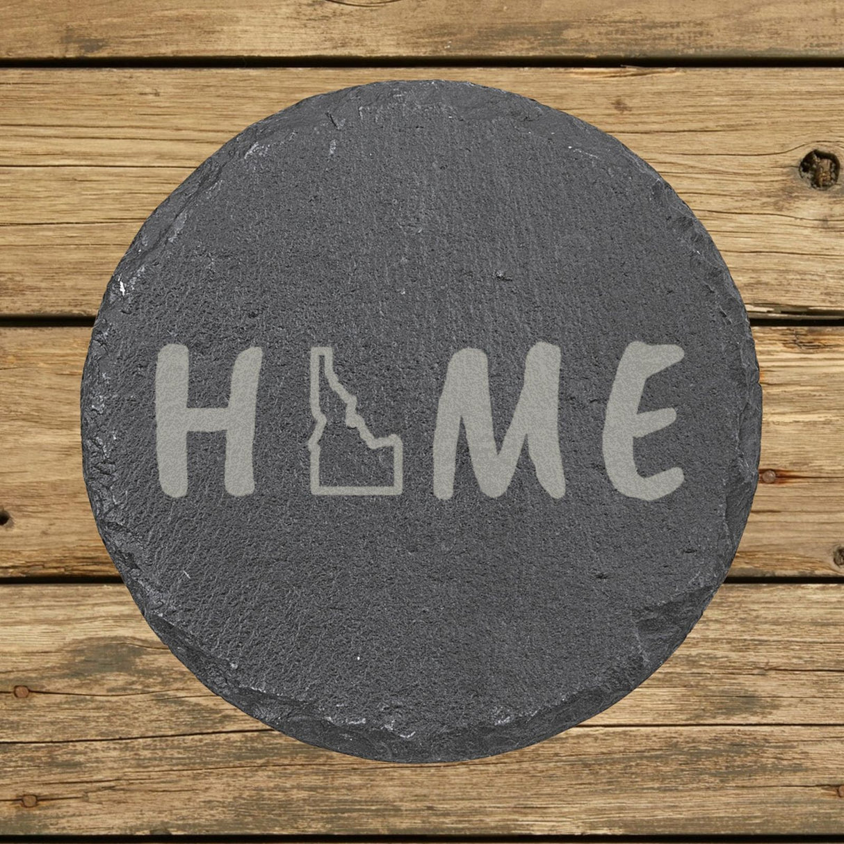 Idaho round slate coaster engraved with HOME using the state outline as the letter O