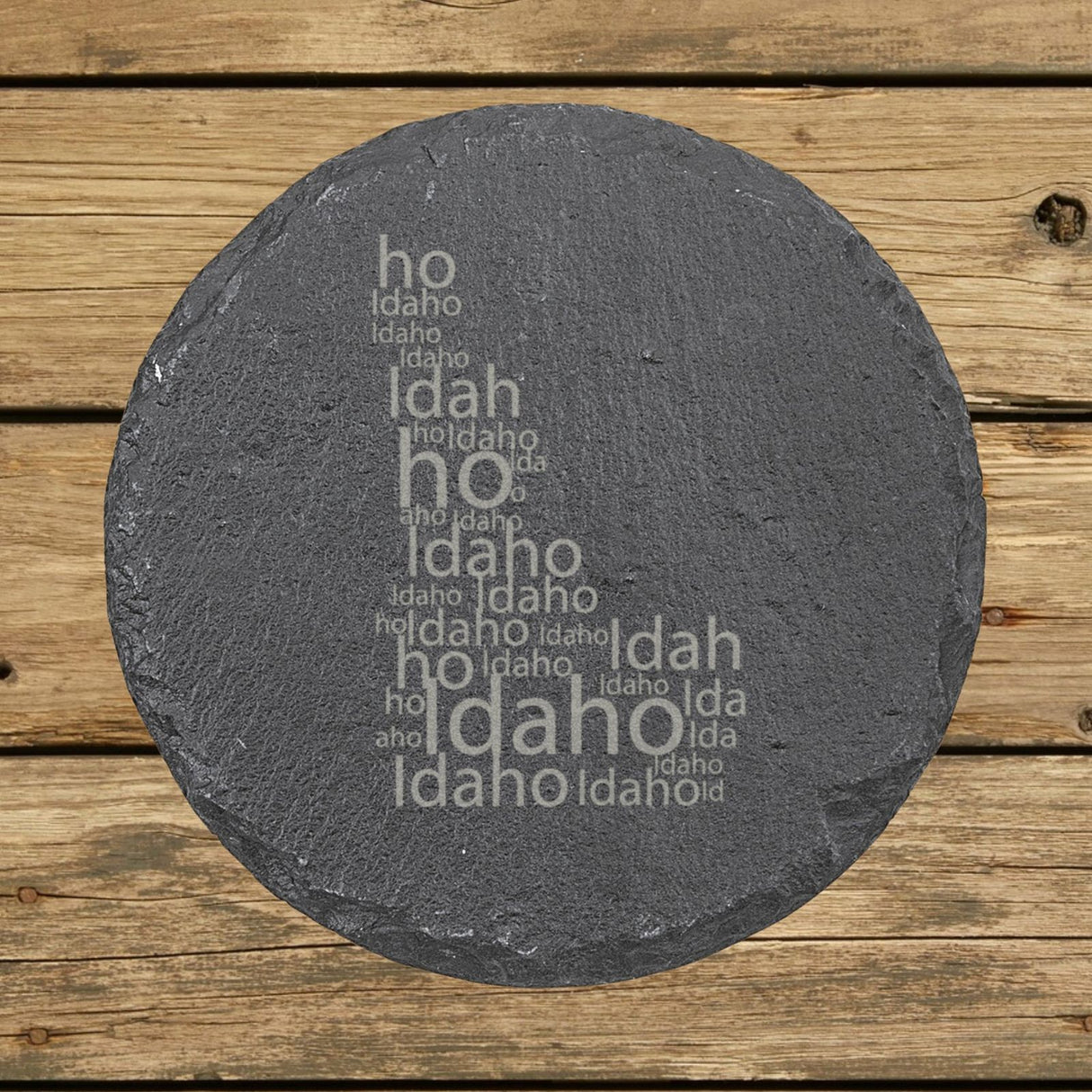 Idaho round slate coaster engraved with a word cloud of repeating Idaho text