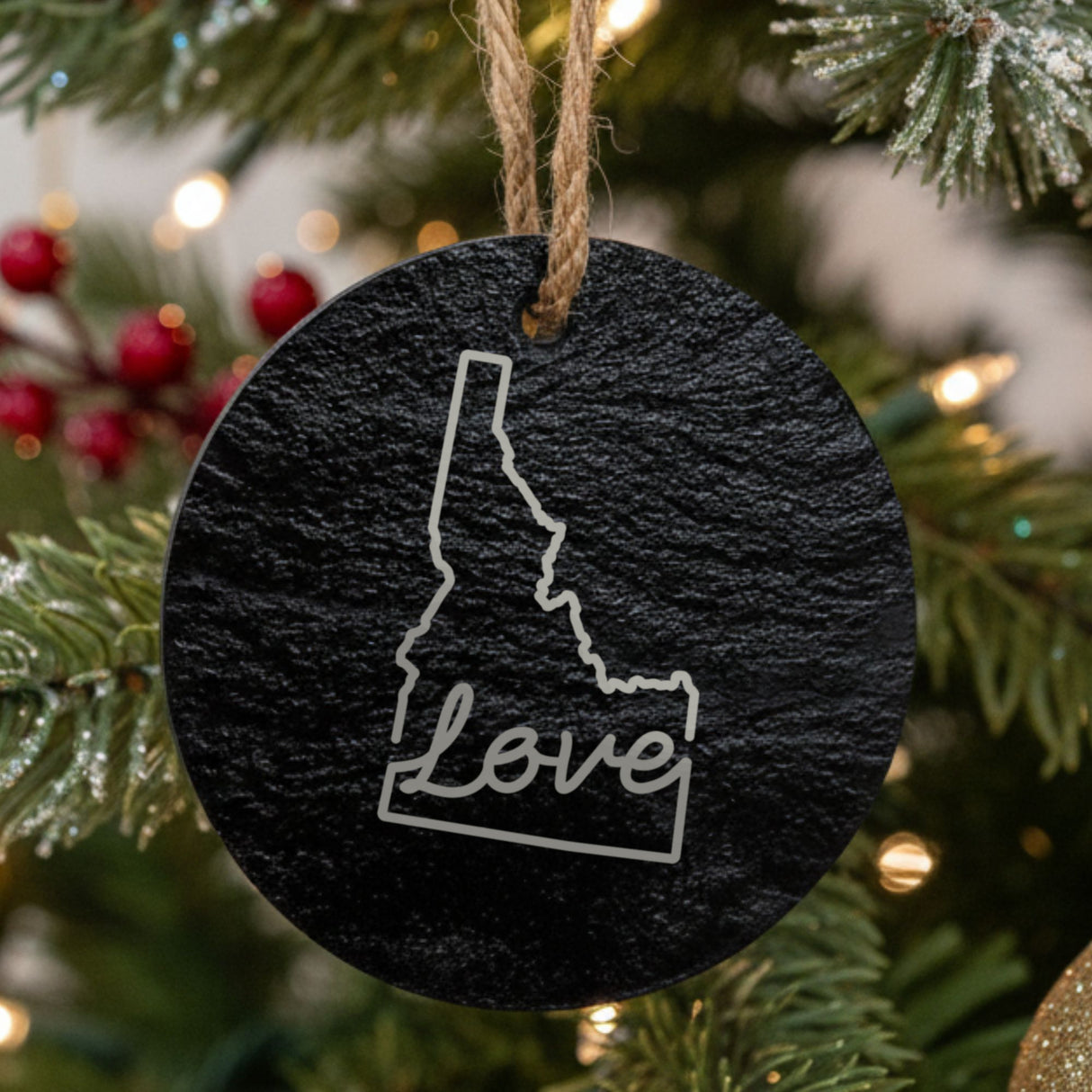 Idaho round slate Christmas ornament engraved with a hand-drawn state outline and love in cursive