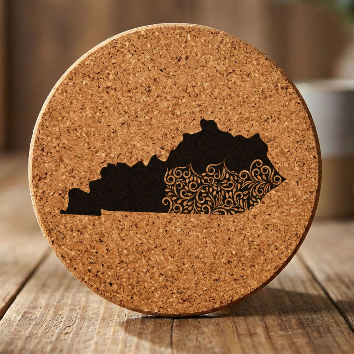 Kentucky round cork coaster engraved with the state shape in ornate floral scrollwork