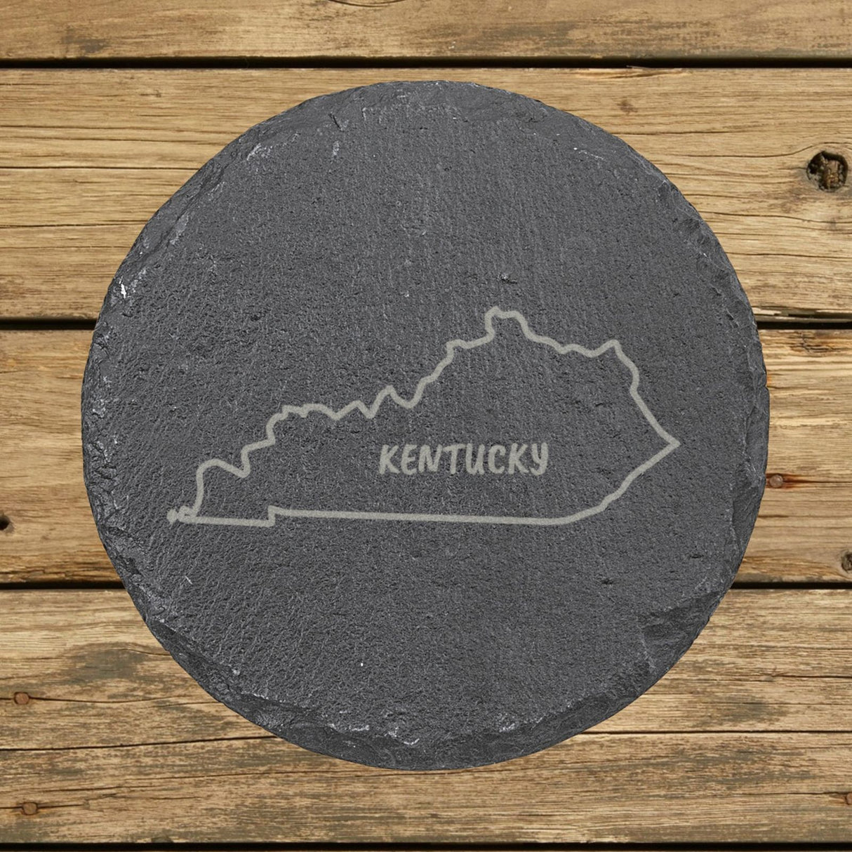 Kentucky round slate coaster engraved with the state outline and KENTUCKY in hand-drawn brush lettering