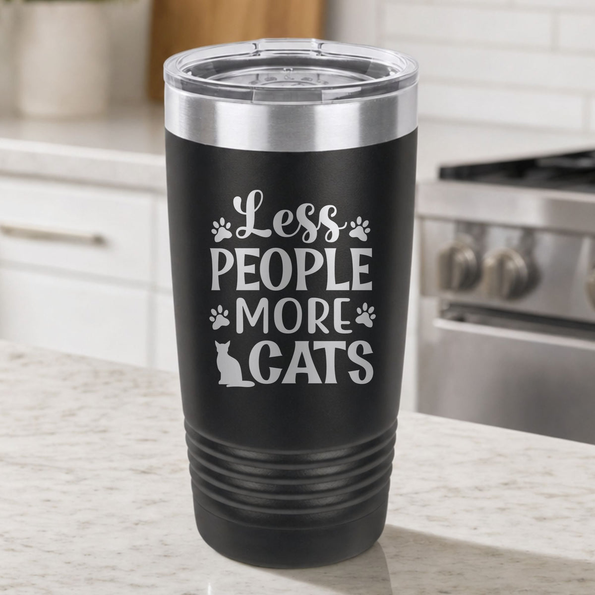 Black 20 oz tumbler laser engraved with "Less People, More Cats", plus paw prints and a sitting cat, on a kitchen counter