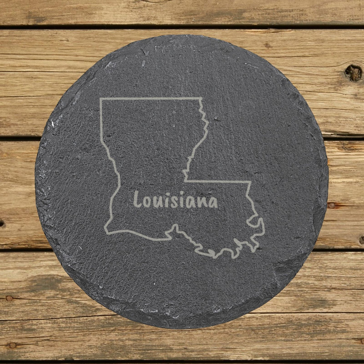 Louisiana round slate coaster engraved with the state outline and LOUISIANA in hand-drawn brush lettering