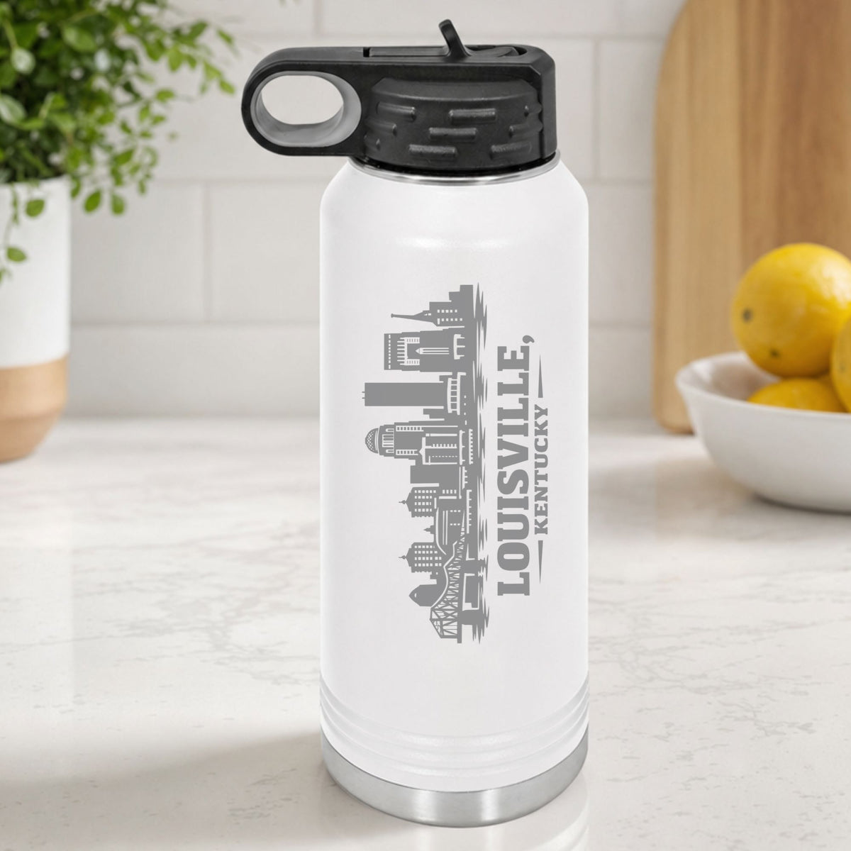 White 32 oz insulated water bottle laser engraved with the Louisville, Kentucky skyline running up the side, standing on a kitchen counter