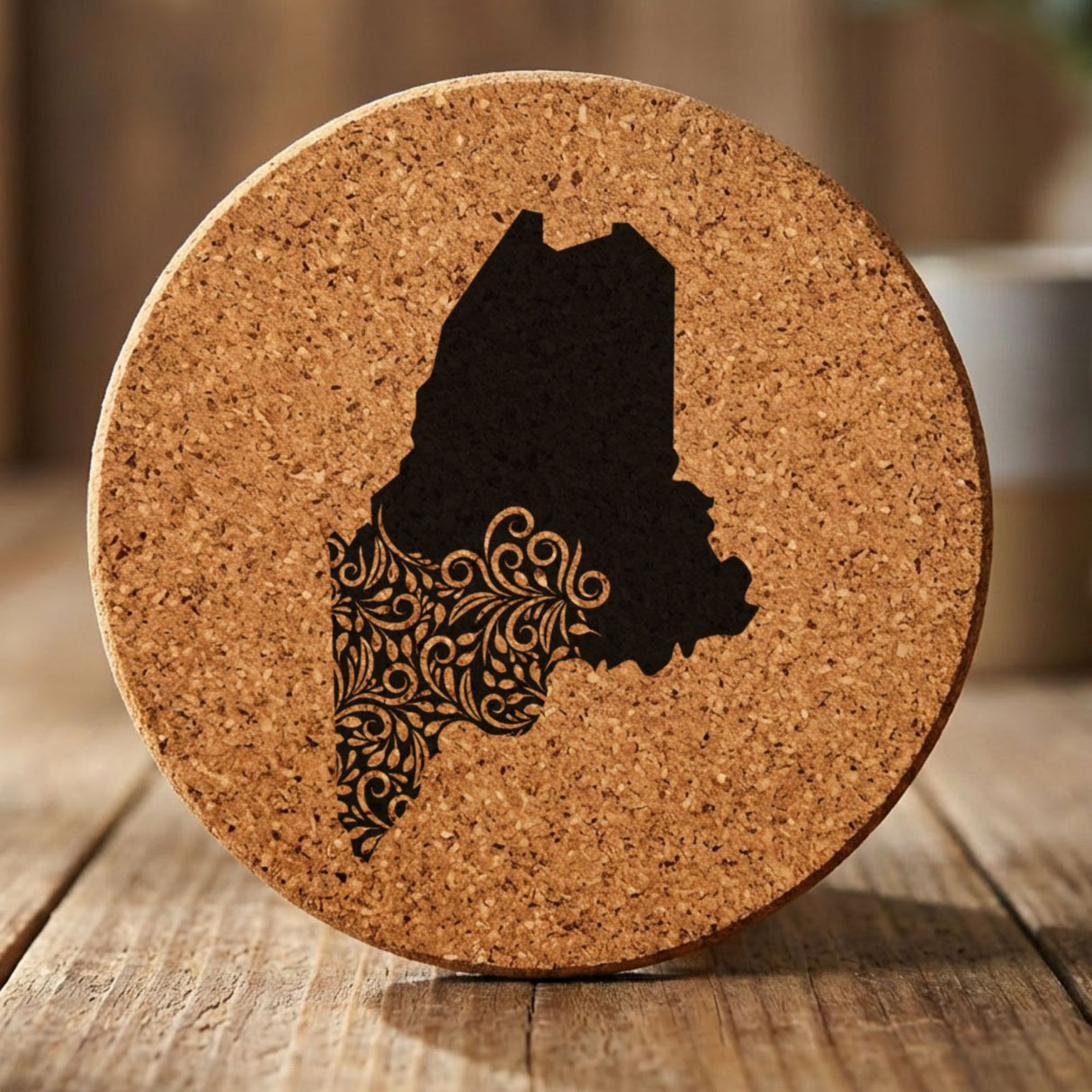 Maine round cork coaster engraved with the state shape in ornate floral scrollwork
