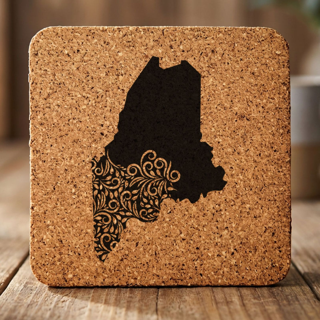 Maine square cork coaster engraved with the state shape in ornate floral scrollwork