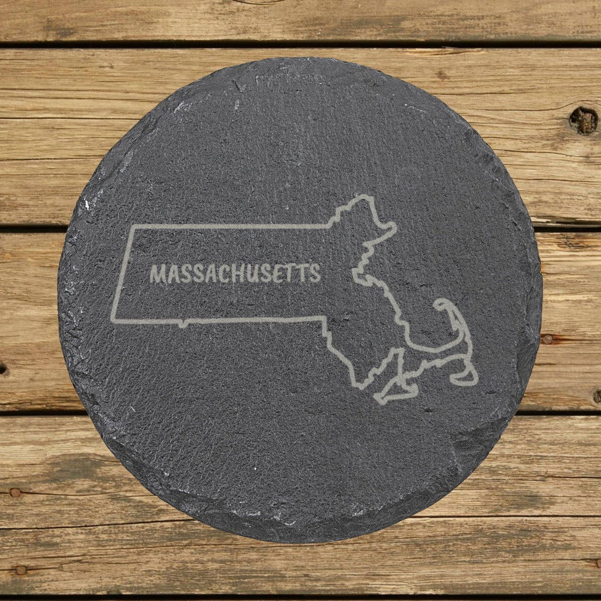 Massachusetts round slate coaster engraved with the state outline and MASSACHUSETTS in hand-drawn brush lettering