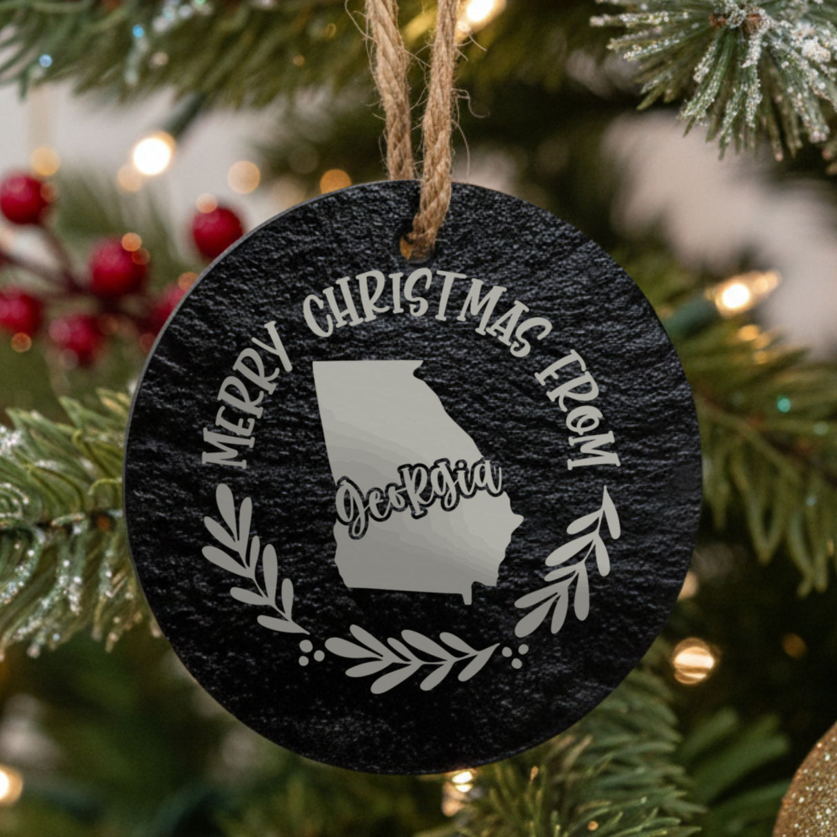 Round slate Christmas ornament engraved Merry Christmas From Georgia, with the state shape in a laurel wreath