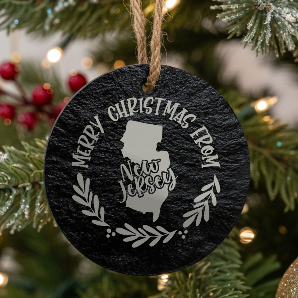 Round slate Christmas ornament engraved Merry Christmas From New Jersey, with the state shape in a laurel wreath