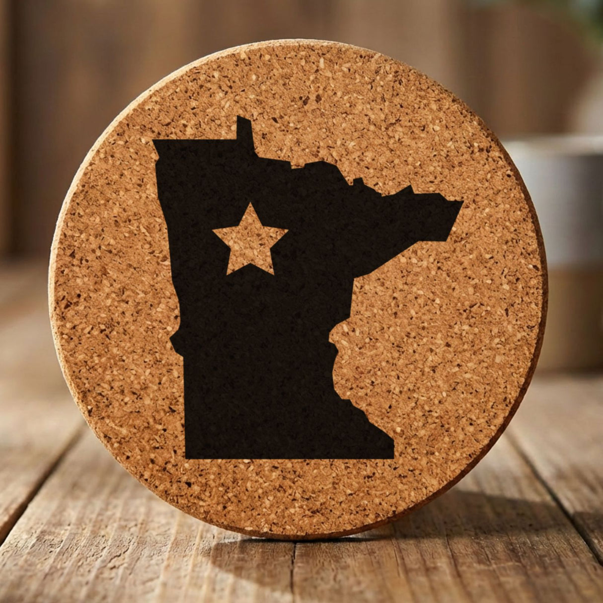Minnesota round cork coaster engraved with the state shape and a star