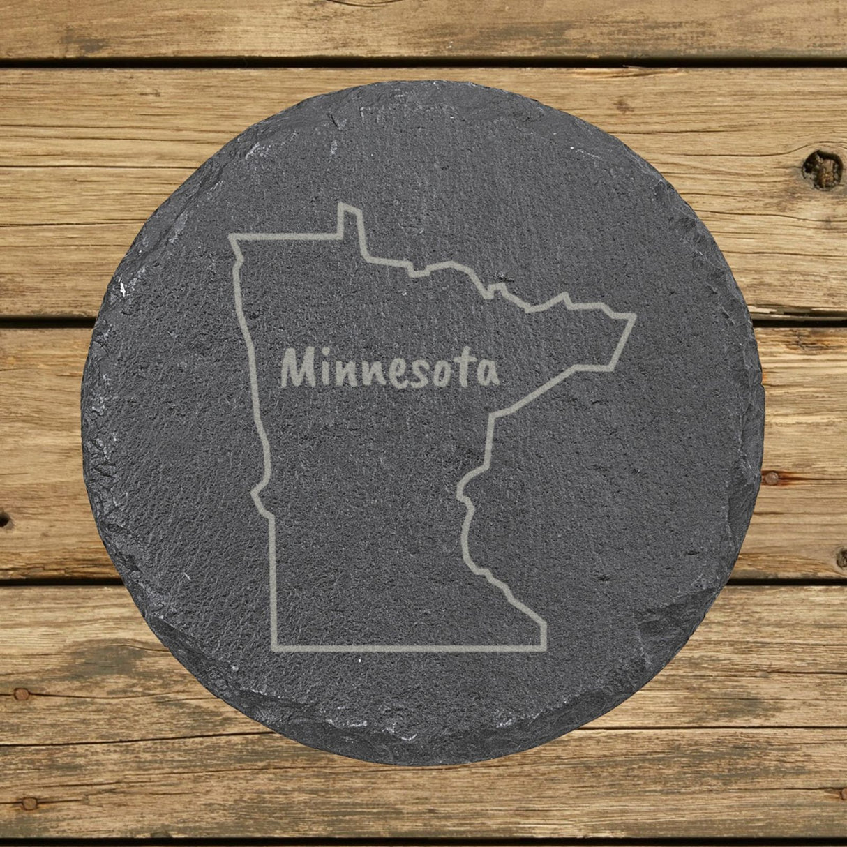 Minnesota round slate coaster engraved with the state outline and MINNESOTA in hand-drawn brush lettering
