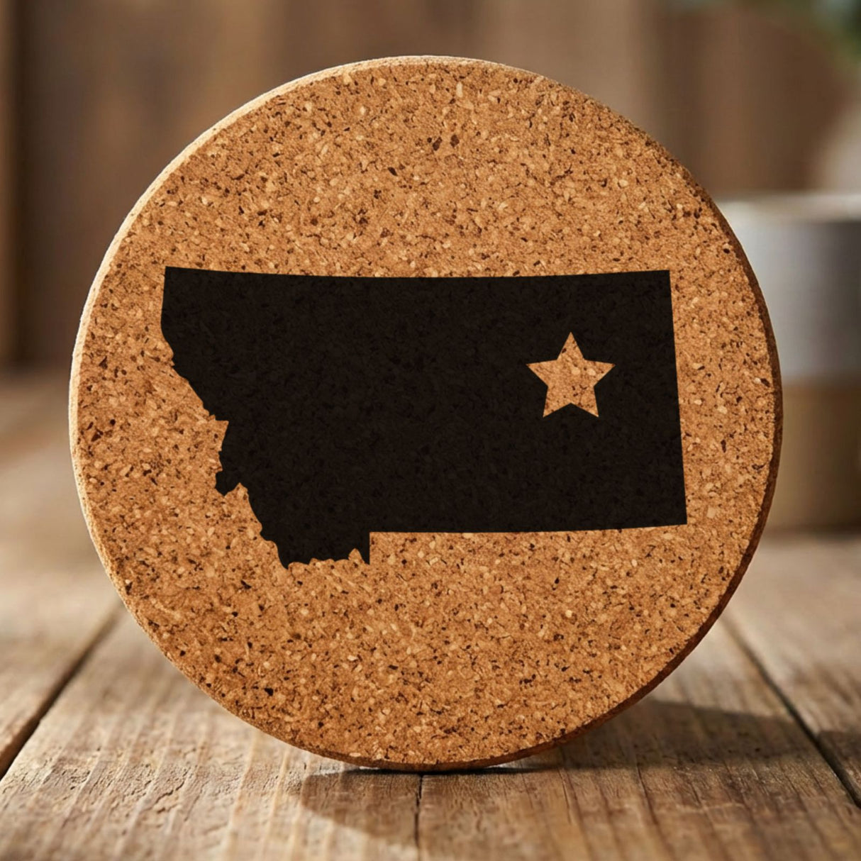Montana round cork coaster engraved with the state shape and a star