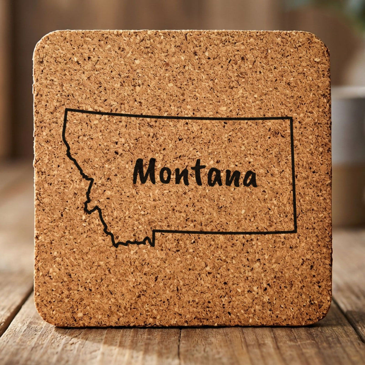 Montana square cork coaster engraved with the state outline and MONTANA in hand-drawn brush lettering