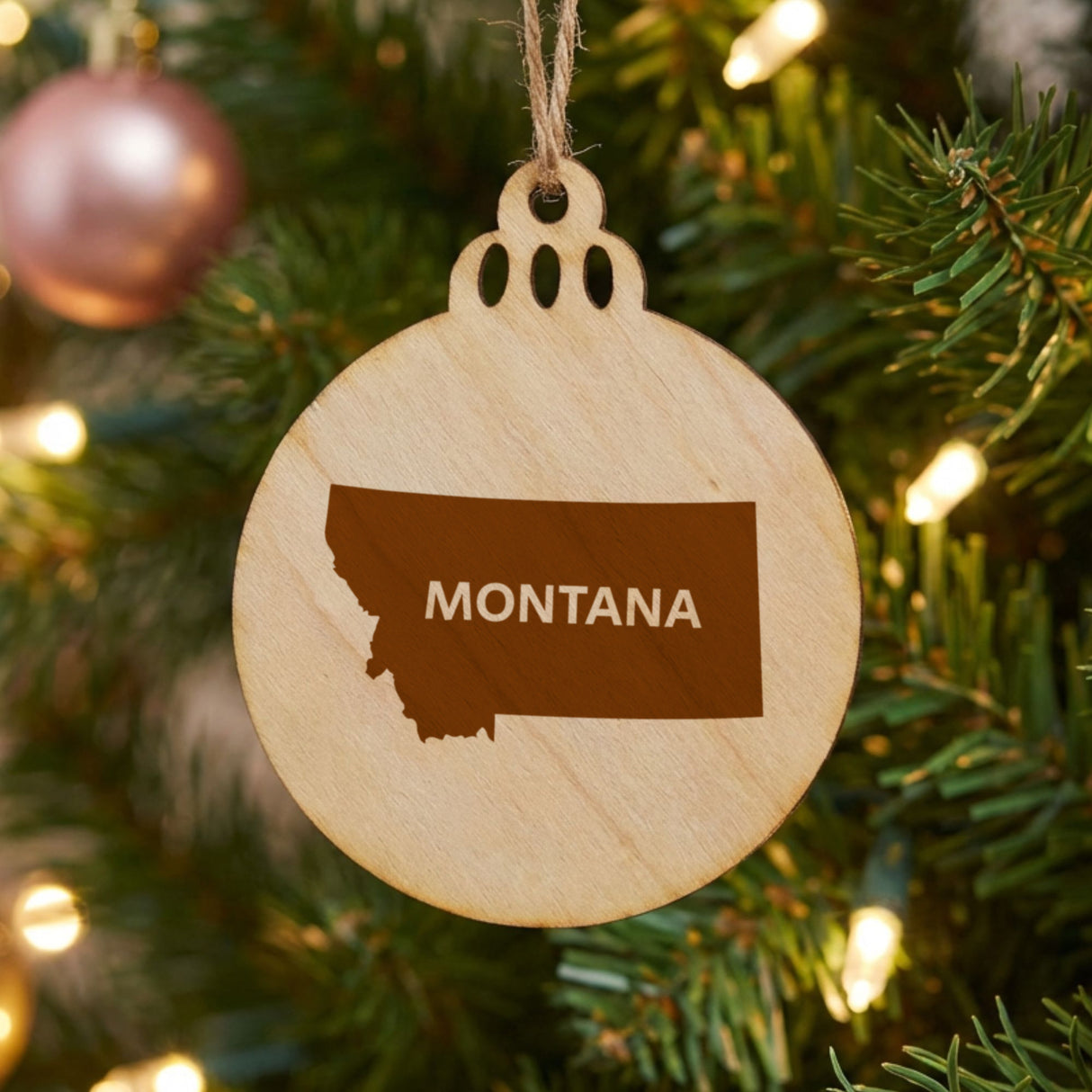 Montana round wood Christmas ornament engraved with the state shape and MONTANA in bold lettering