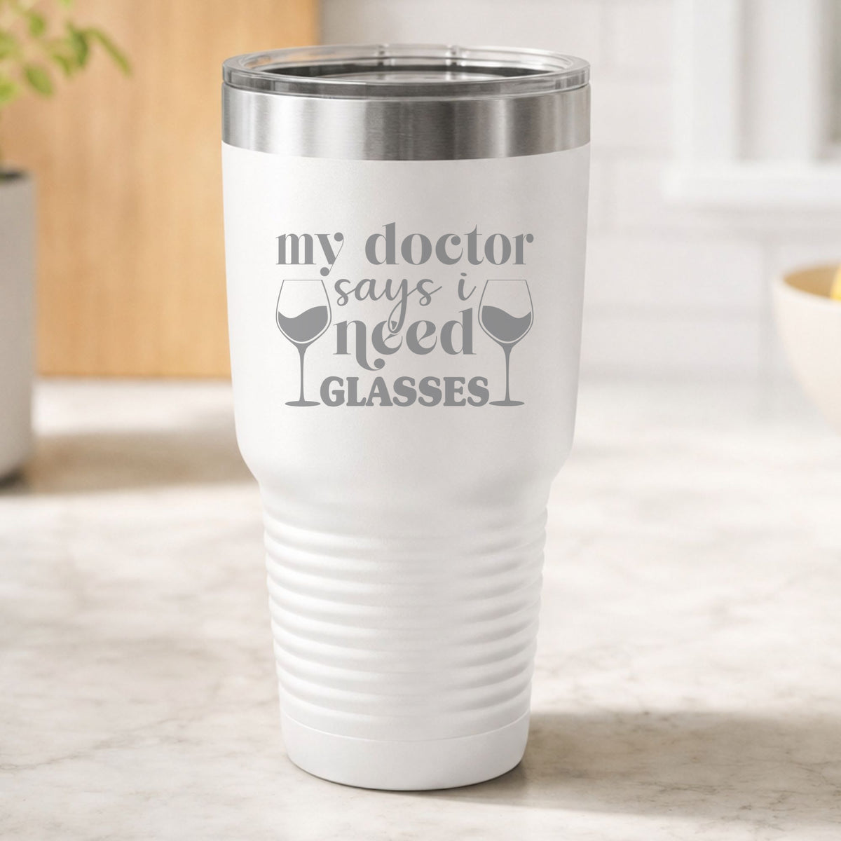 White 30 oz tumbler laser engraved with "My Doctor Says I Need Glasses", on a kitchen counter