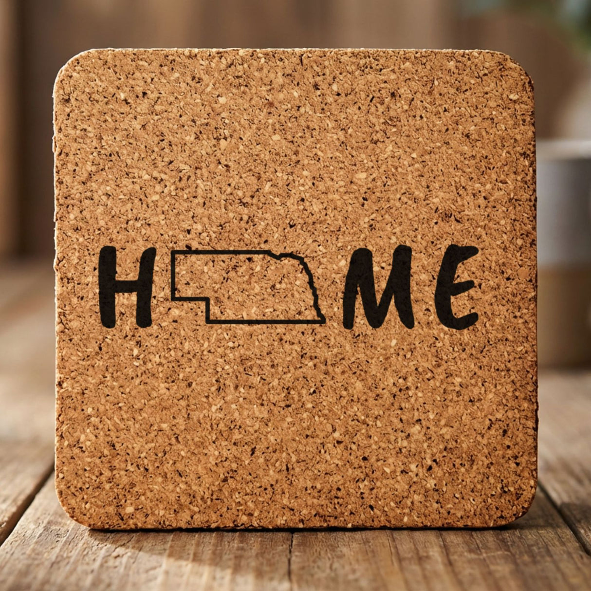 Nebraska square cork coaster engraved with HOME using the state outline as the letter O