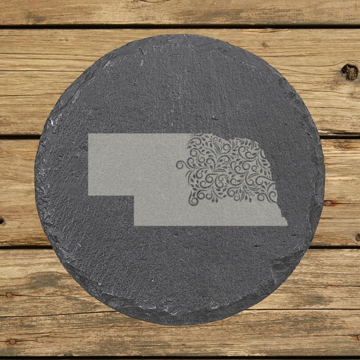 Nebraska round slate coaster engraved with the state shape in ornate floral scrollwork