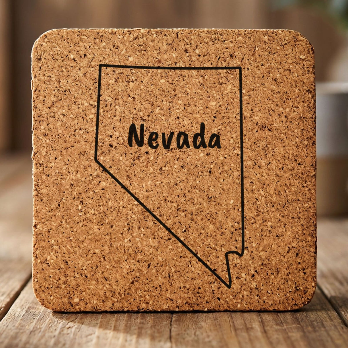 Nevada square cork coaster engraved with the state outline and NEVADA in hand-drawn brush lettering