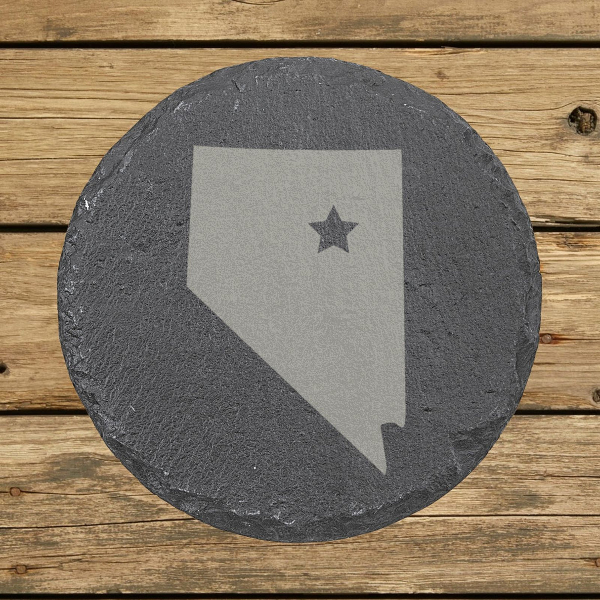 Nevada round slate coaster engraved with the state shape and a star