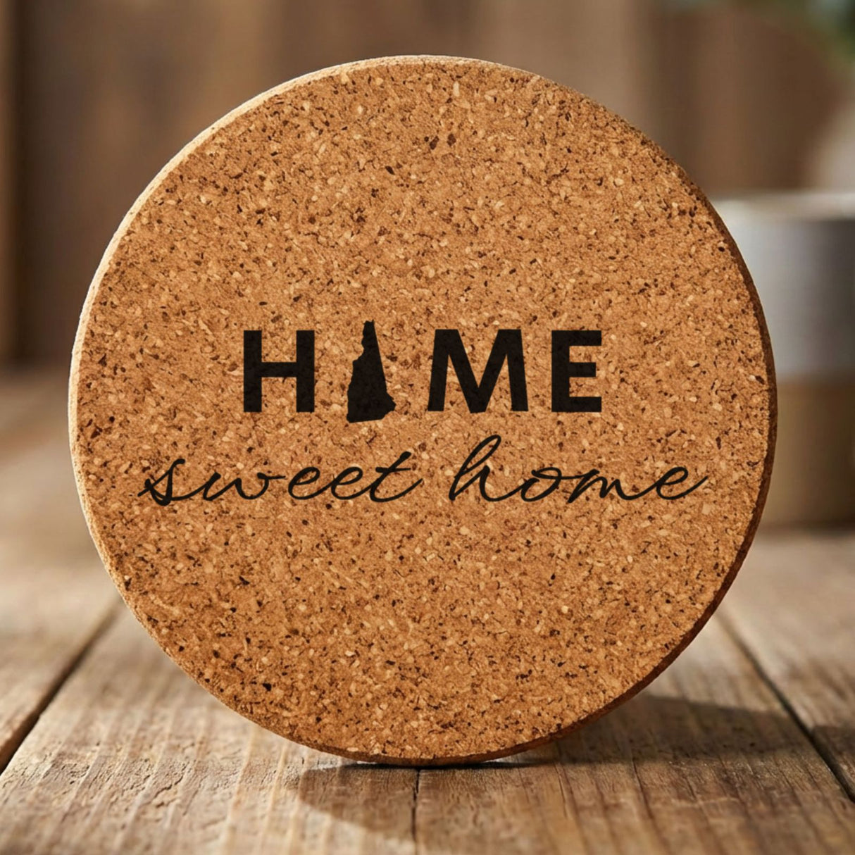 New Hampshire round cork coaster engraved with HOME sweet home using the state shape as the letter O