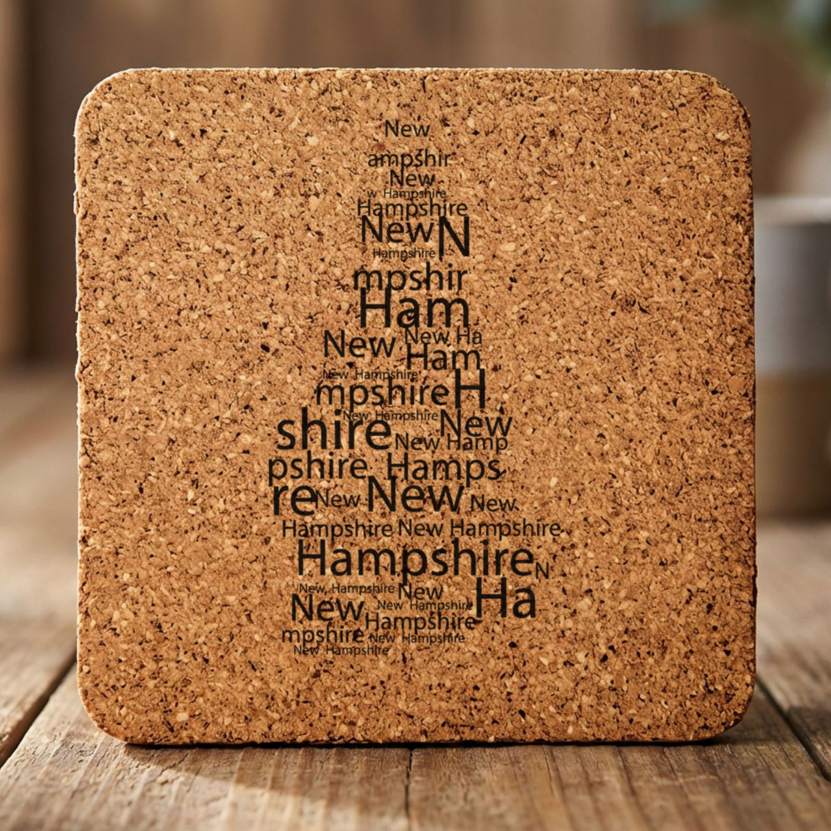 New Hampshire square cork coaster engraved with a word cloud of repeating New Hampshire text