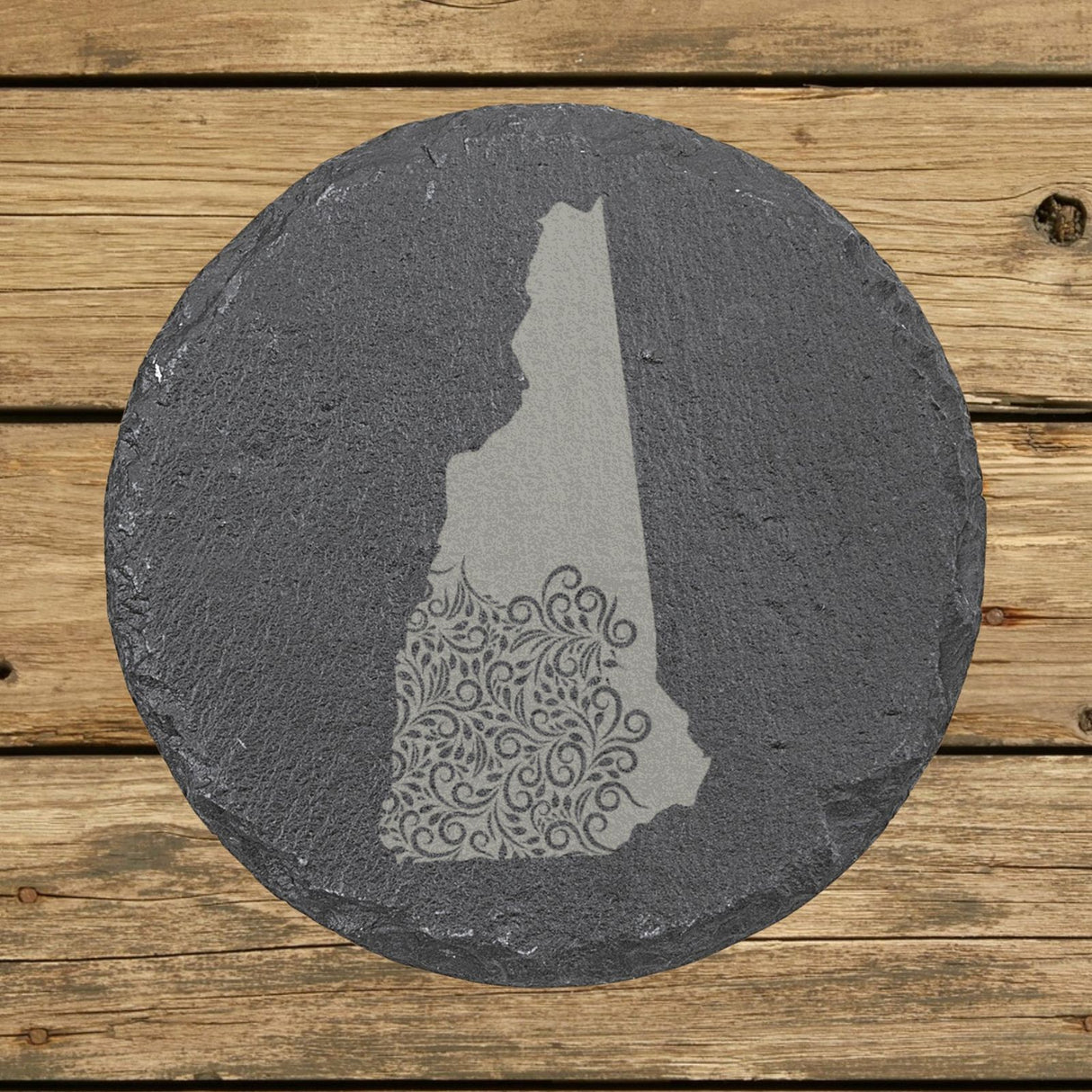 New Hampshire round slate coaster engraved with the state shape in ornate floral scrollwork