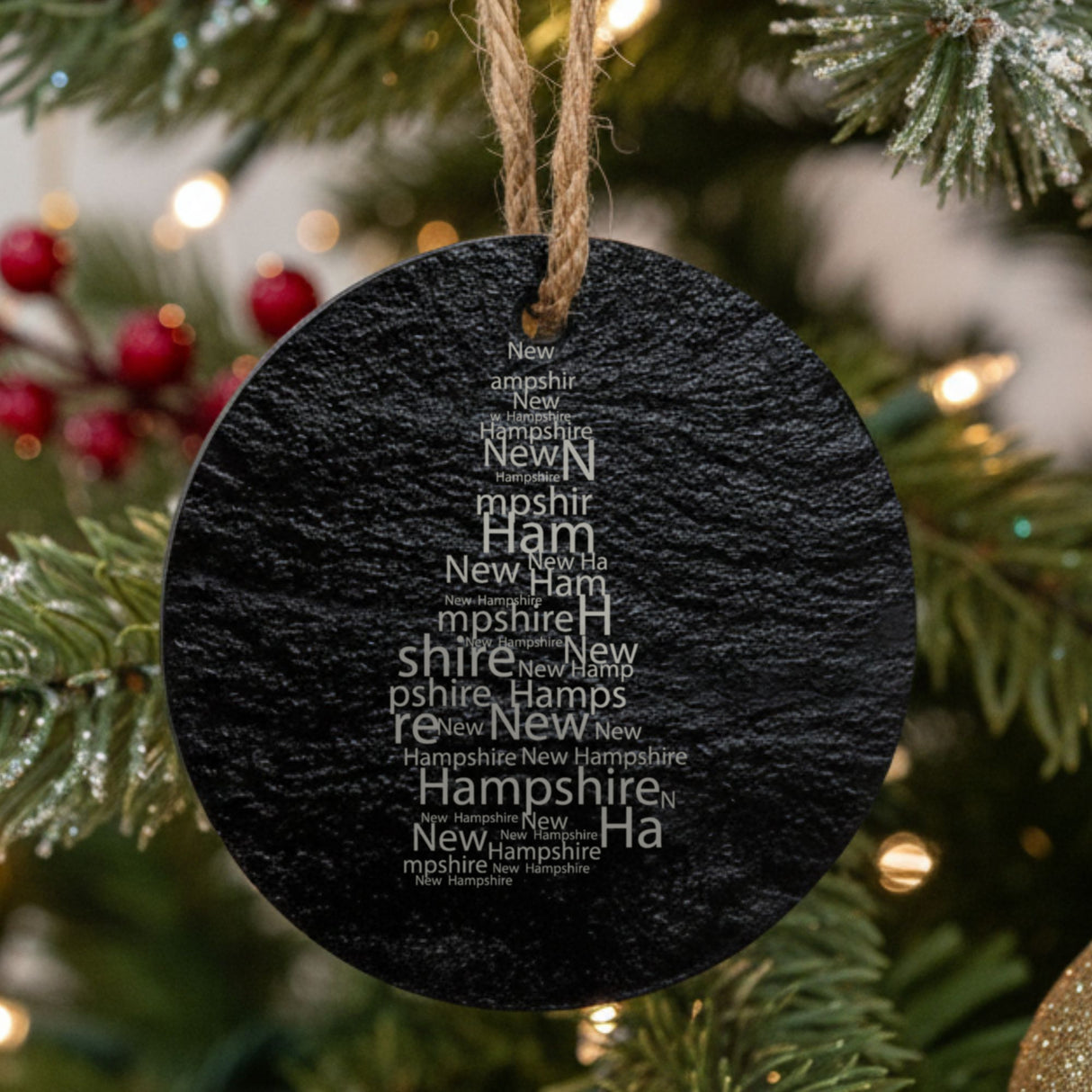 New Hampshire round slate Christmas ornament engraved with a word cloud of repeating New Hampshire text