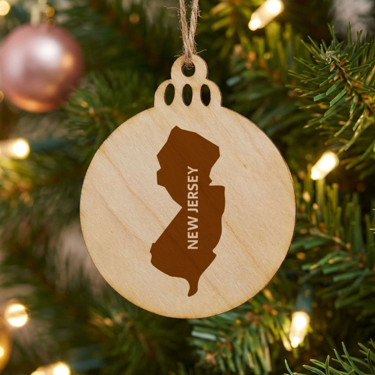 New Jersey round wood Christmas ornament engraved with the state shape and NEW JERSEY in vertical lettering