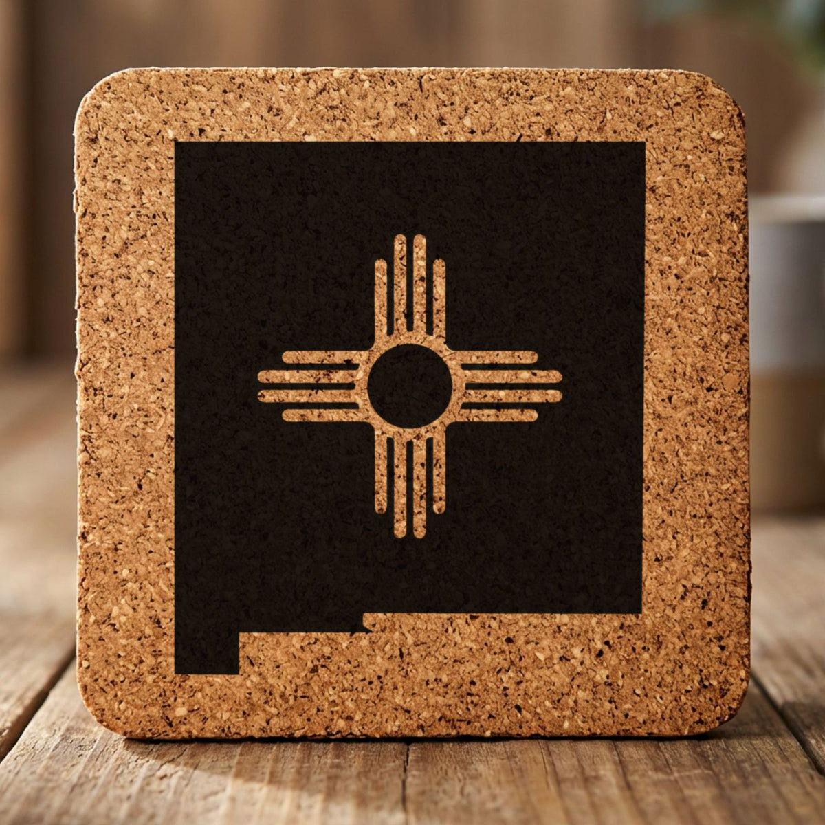 New Mexico square cork coaster engraved with the state shape and the Zia sun symbol